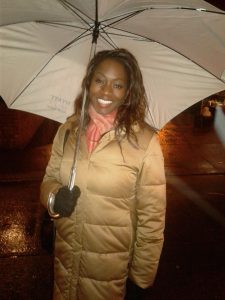 Azania shelters from the rain after an interview at Lido Restaurant in Harlem, New York